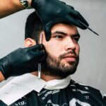 Close-up of a professional men's haircut in West Palm Beach, with a barber carefully shaping the client’s beard.