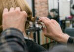 Stylist trimming a client’s hair during a consultation about what is the best hair style for different face shapes